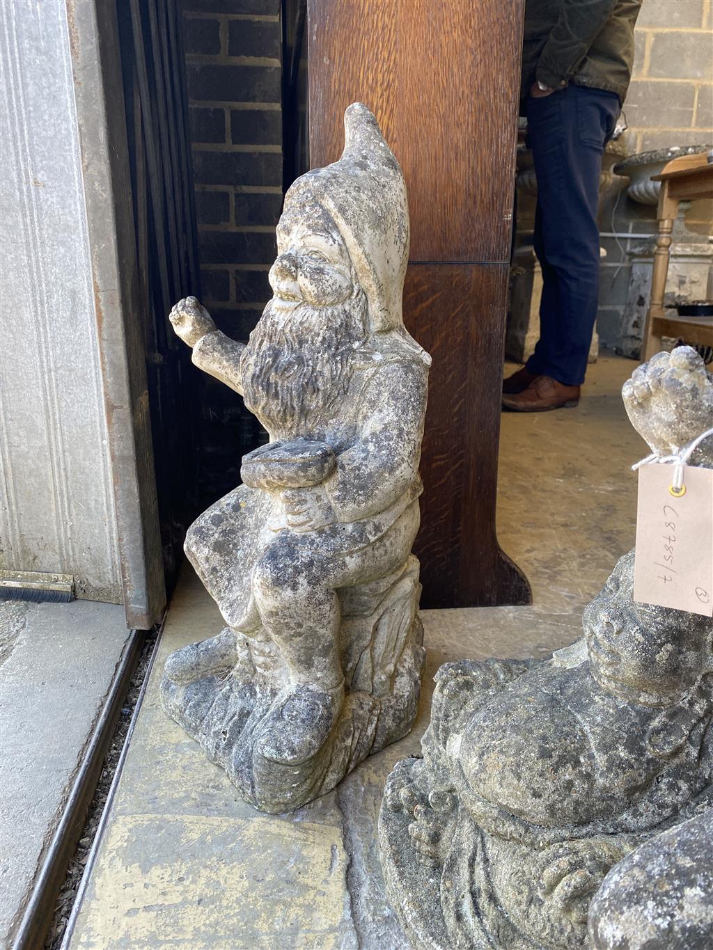 A pair of reconstituted stone garden gnomes, height 62cm together with a seated Buddha